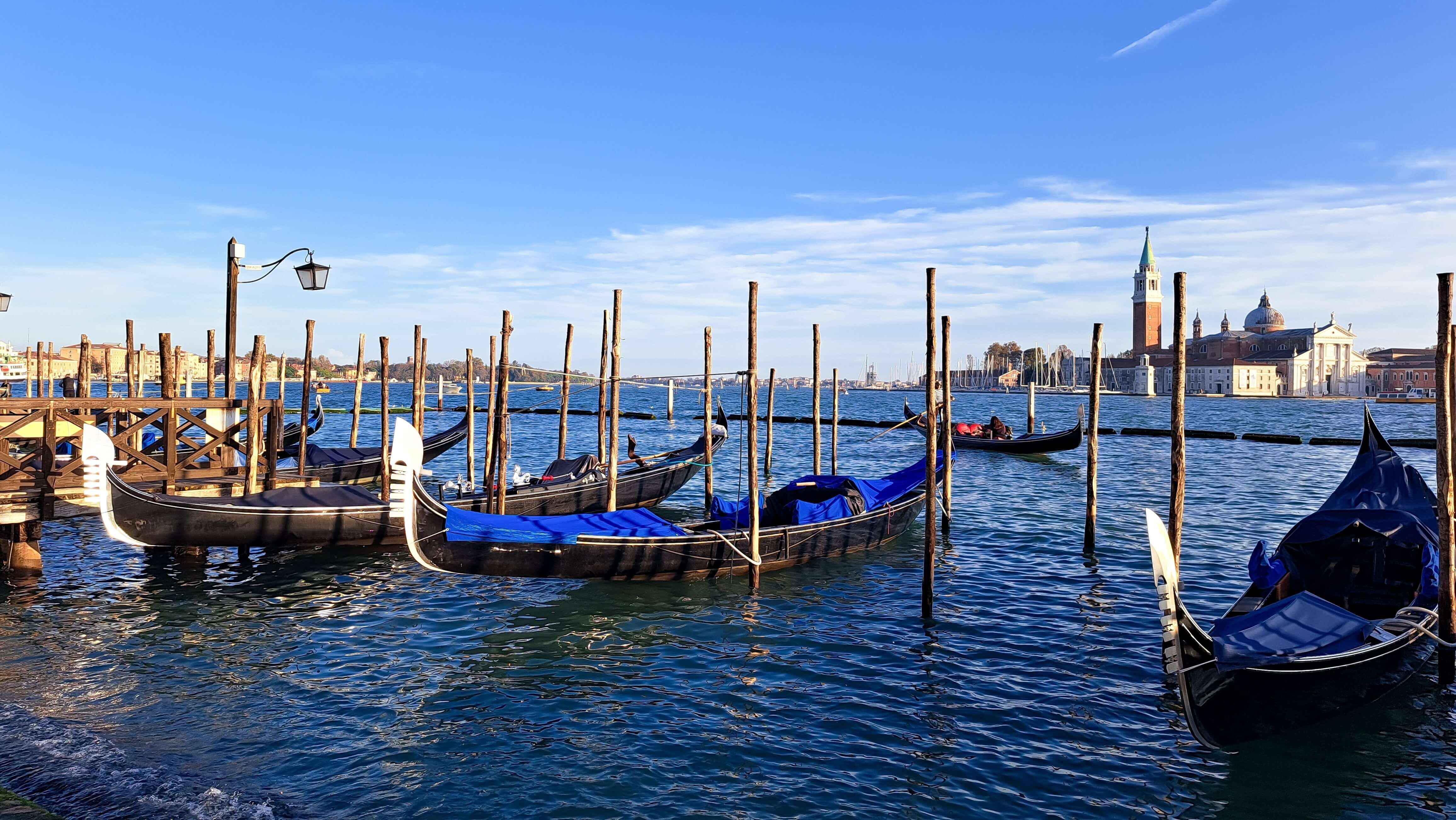 Beautiful seascape with gondolas on the blue sea water in Venice, Italy.